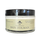 Don Tolman Divine Body Butter jar with a label, showcasing rich, moisturizing skincare product in a natural setting.