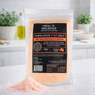 Himalayan fine salt in a 900g salt container from SaltCo, showing pink grains and textured surface.